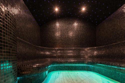 WolbórzHotel Fox的砖墙房间的游泳池