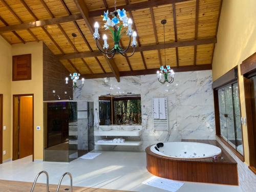 蒙特韦尔迪Chalés Recanto das Montanhas的带浴缸和盥洗盆的大浴室