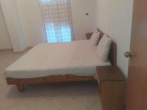 赫尔格达Sheraton ap .的一间卧室配有一张带白色床单的床和一扇窗户。