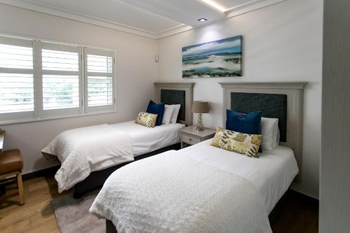 赫曼努斯Bayview 203的带2扇窗户的客房内的2张床
