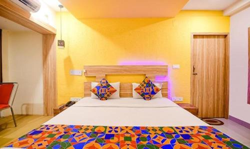 KhandagiriFabHotel Sai Jagannath Residency的一间卧室配有一张大床和彩色床罩