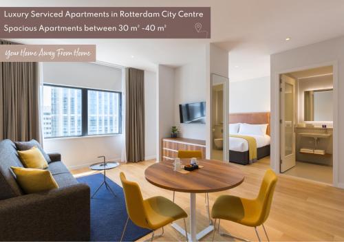 鹿特丹鹿特丹尊贵套房公寓的酒店客房带一张床、一张桌子和椅子