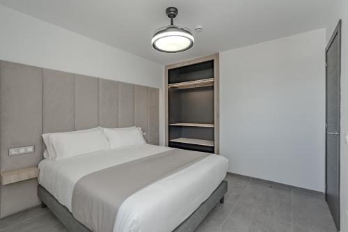 阿德耶Costa Adeje Garden Aparthotel的卧室配有一张白色大床和一个衣柜