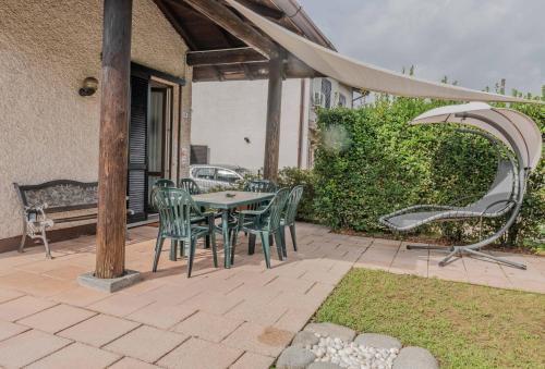 维佐拉提契诺[Ca' Roby] Malpensa Airport relax - Free Wifi的庭院配有桌椅和遮阳伞。