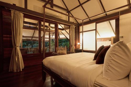 清迈Jambolan Chiangmai的一间设有床铺的卧室,位于带窗户的房间内
