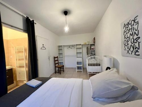 卢瓦尔河畔叙利Sully-sur-loire: Agréable maison en centre ville的卧室配有白色的床和婴儿床。