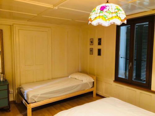 布格多夫Simple Appartment in the Center of Burgdorf 64 m2 with private Parking - SMALL BATHROOM的客房设有床、窗户和吊灯。