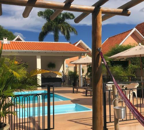 博尼图查莱公寓酒店的一个带遮阳伞的游泳池和一个度假村