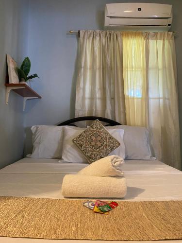 塔比拉兰Angel's Place Transient House的一张带白色毯子和枕头的床