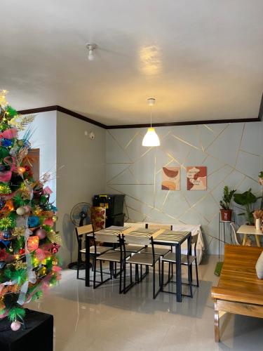塔比拉兰Angel's Place Transient House的一间设有桌子和圣诞树的用餐室