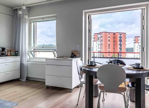 拉彭兰塔Light modern Pallo apartment by the lake Saimaa的厨房配有桌椅和窗户。