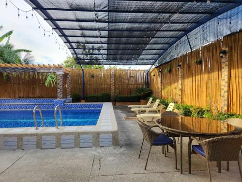潘索尔TRD Private Hotspring Resort的庭院设有游泳池和桌椅
