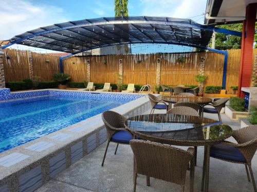 潘索尔TRD Private Hotspring Resort的游泳池旁带桌椅的天井