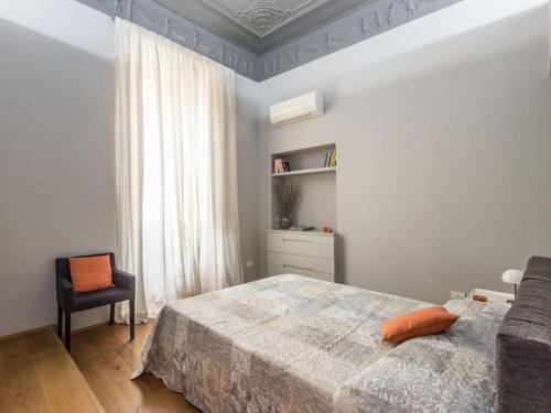 罗马Luxury Fori Imperiali Flat的卧室配有床、椅子和窗户。