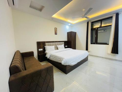 哈里瓦Divine Ganga by MJ Hospitality的一间卧室配有一张床和一张沙发
