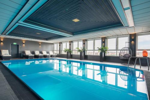 达姆施塔特达姆施塔特贝斯特韦斯特广场酒店的一座大型游泳池,位于一座拥有大型天花板的建筑内