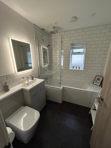 特雷杜尔Garreg Fawr Trearddur Bay - Ty Melyn的浴室配有卫生间、浴缸和水槽。