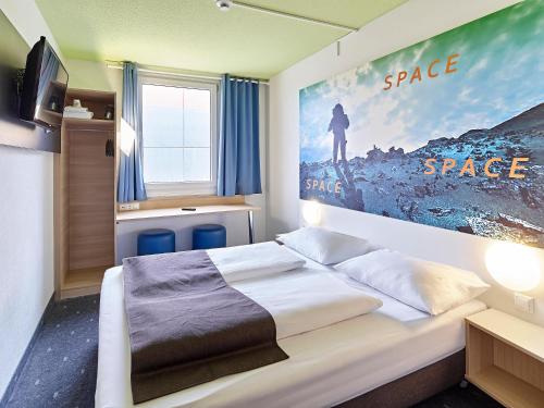 科隆科隆机场B&B酒店的卧室配有一张壁挂式海报的床