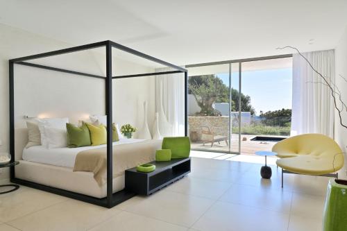 博尼法乔卡拉迪格雷科酒店的一间带天蓬床的卧室和一间客厅