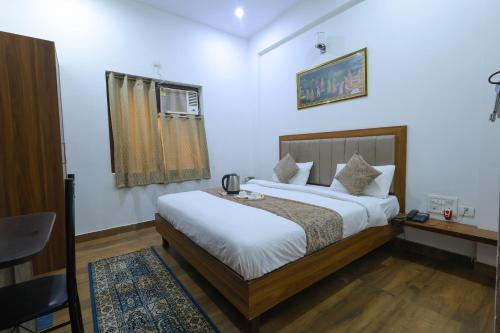 阿格拉Taj Classic Agra的一间卧室配有一张床、一张书桌和一个窗户。