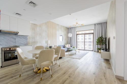 迪拜Nasma Luxury Stays - Fabulous Apartment With Balcony Near MJL's Souk的厨房以及带桌椅的起居室。
