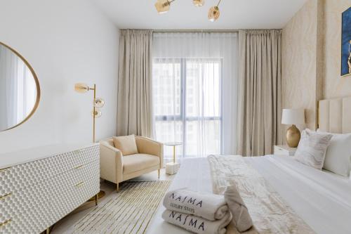迪拜Nasma Luxury Stays - Fabulous Apartment With Balcony Near MJL's Souk的白色卧室配有床和椅子