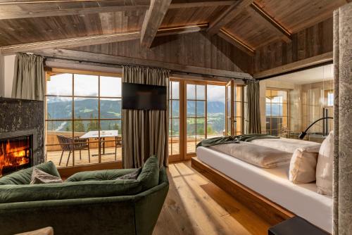 斯拉德明奥地利阿尔姆威特酒店的一间卧室设有一张大床和一个壁炉
