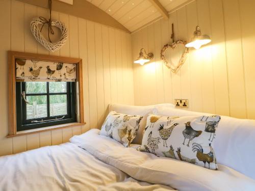 诺丁汉Poppie's Shepherds Hut的客房设有带枕头的沙发和窗户。