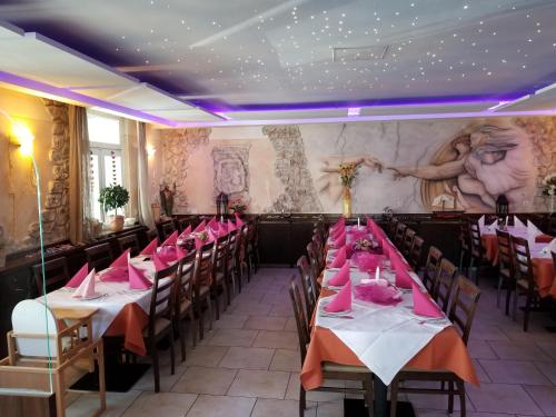 SüßenHotel im Gässle的用餐室配有桌椅和粉红色餐巾