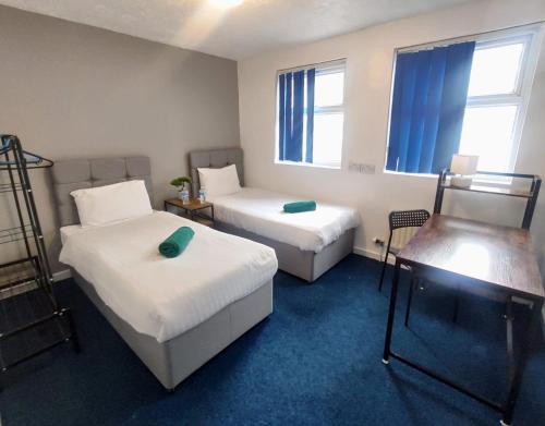 利物浦利物浦皇家钱伯斯酒店的客房设有两张床、一张桌子和两个窗户。