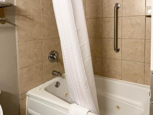 纳科多奇斯Motel 6 Nacogdoches TX SFA University的带浴缸和淋浴帘的浴室
