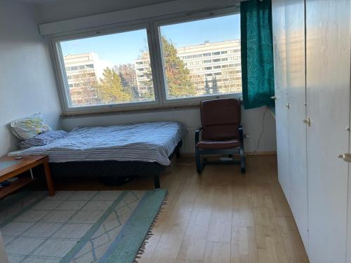 赫尔辛基An entire flat 60m2 with a balcony in Itakeskus of Helsinki的卧室配有床、椅子和窗户。