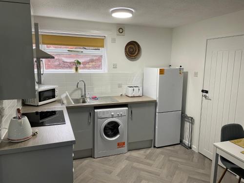 HednesfordThe Uxbridge Suite的厨房配有洗衣机和冰箱。