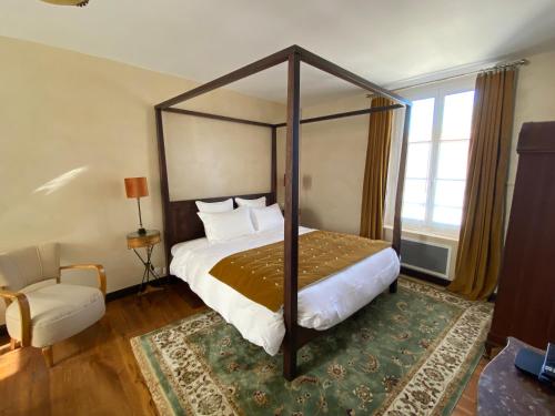 蒙福尔拉莫里LA THEBAUDERIE的一间卧室配有一张天蓬床和一把椅子