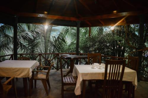 代尼耶耶辛哈拉加莱斯特旅馆的一间餐厅设有两张桌子和椅子以及一把遮阳伞
