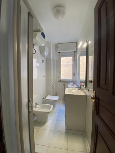 萨萨里Residence La Peonia的白色的浴室设有水槽和卫生间。