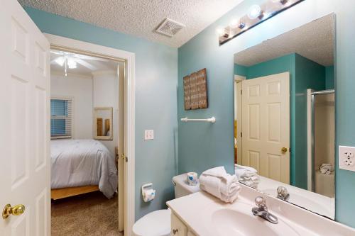奥兰治比奇Enclave 304的一间带水槽和镜子的浴室以及一张床