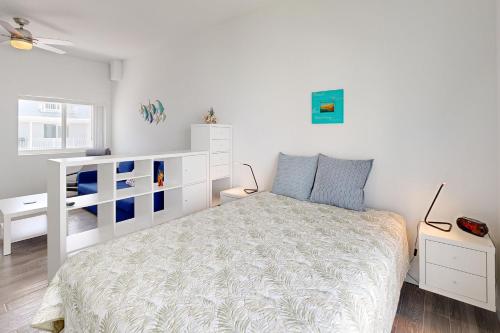 马拉松Sea Grape Getaway的卧室配有白色的床和白色梳妆台