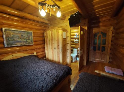 亚列姆切Дерев'яний котедж "Казка"的小木屋内一间卧室,配有一张床