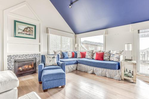 卡农海滩Cannon Beach Saltbox Cottage的客厅设有蓝色的沙发和壁炉