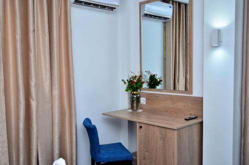 DjerbaHôtel Joya Paradise & SPA Djerba的浴室设有镜子和蓝色椅子