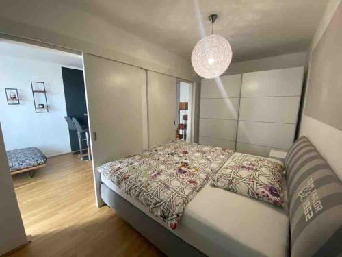 维也纳Moderne Wohnung in der Toplage inkl. Garage的一间卧室配有一张床和一个吊灯