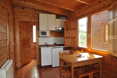 希奥Bungalows Sol e Mar的厨房配有桌子和白色炉灶烤箱。