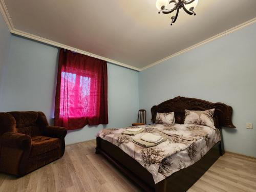 甘贾Michael House的卧室配有床、椅子和窗户。