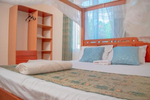 基利菲Unique Homes One- Bedroom Apartment的一间卧室配有一张带蓝色枕头的床和一扇窗户。
