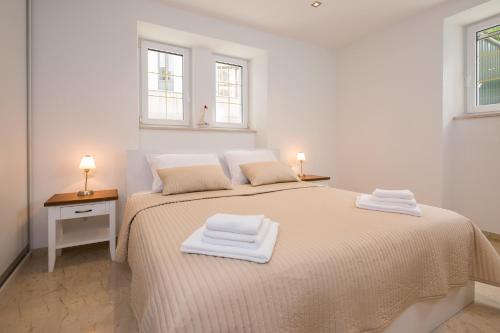 斯普利特Superior Apartment CASA SPALATO的白色卧室配有带2条毛巾的床