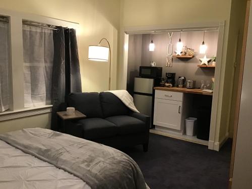 罗克波特Star Suite on the Midcoast的一间卧室配有一张床和一把椅子,一间厨房