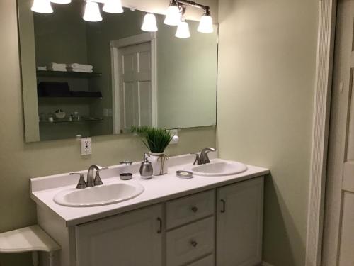 罗克波特Star Suite on the Midcoast的一间带两个盥洗盆和大镜子的浴室