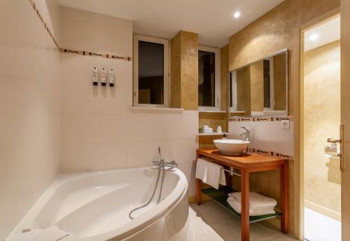 维泰勒Providence Hotel的带浴缸和盥洗盆的浴室