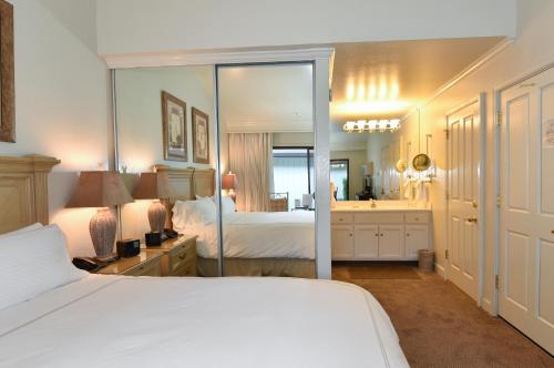 纳帕Getaway Suite at Silverado in Napa的卧室配有白色的床和镜子